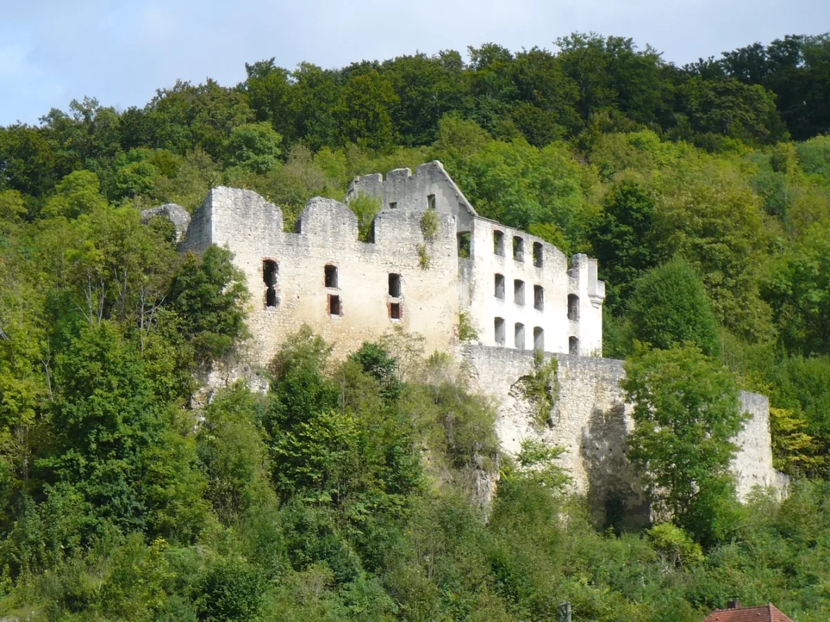 Burg Schülzburg: Südwestansicht mit Ringmauer mit Öffnung, mehrgeschossiger Schlossbau, und Palas der Burg (re.)