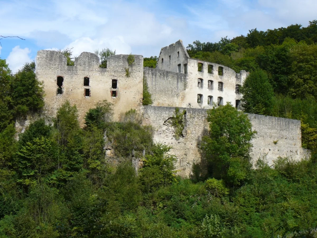 Burg Schülzburg: Südwestansicht mit Ringmauer mit Öffnung, mehrgeschossiger Schlossbau, und Palas der Burg (re.)
